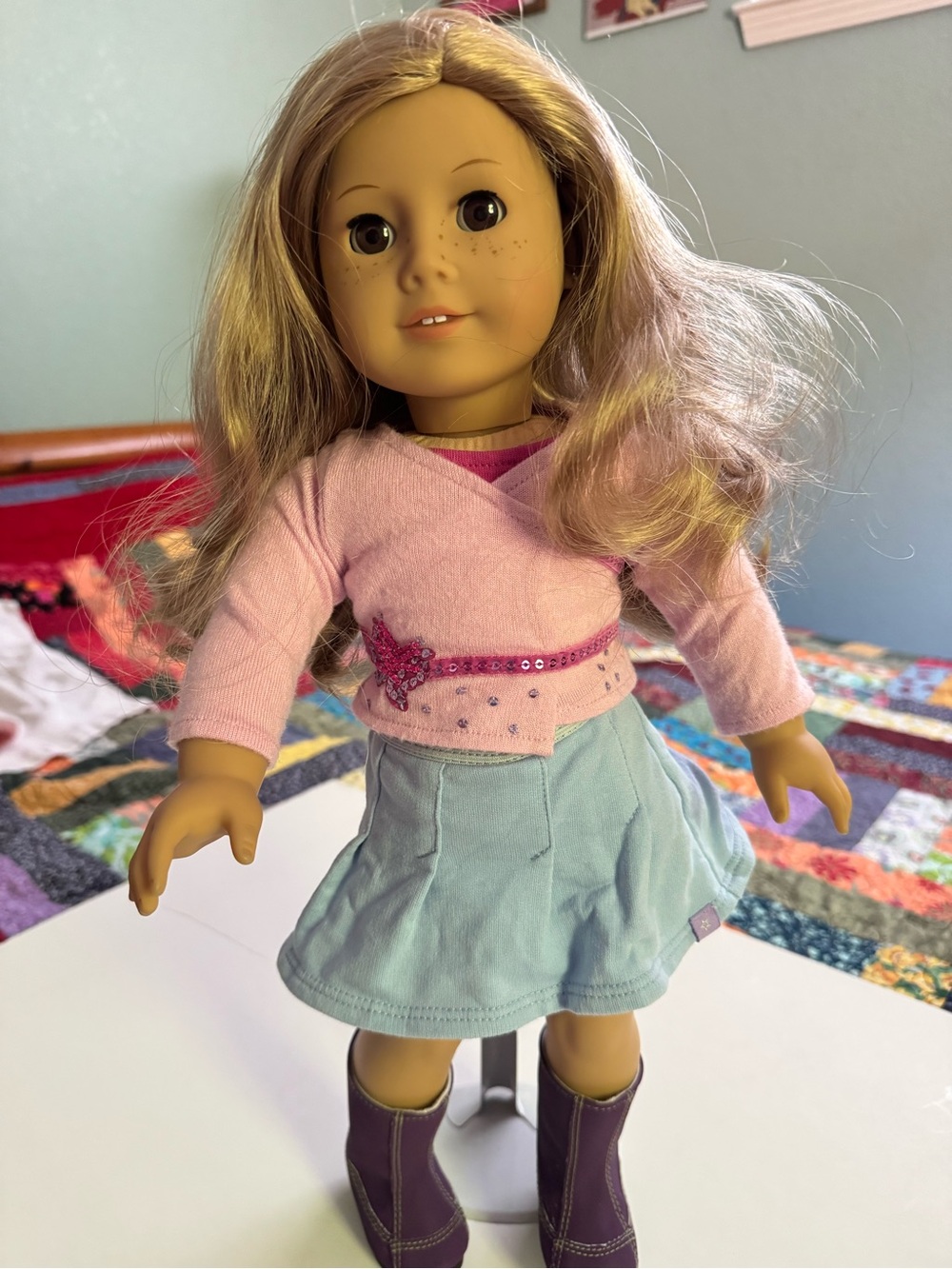 American Girl Blonde Doll with original pink top, blue skirt and purple boots .